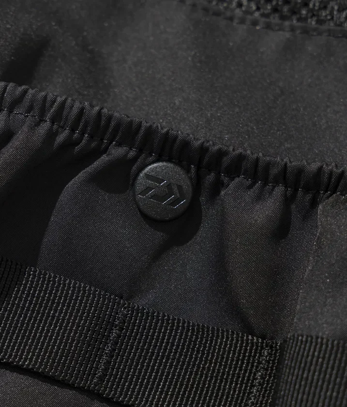 黒い生地のクローズアップ画像で、中央にはDAIWAのロゴが入ったボタンがあり、その下には黒い織りストラップが見えます。