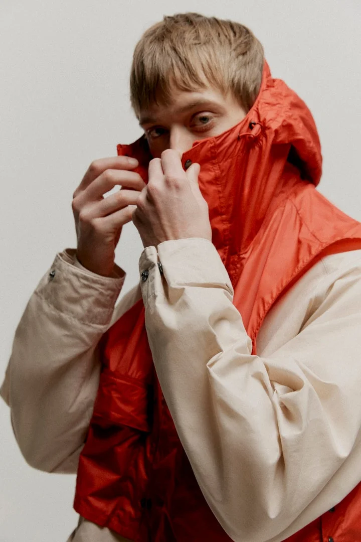 オレンジ色のフード付きジャケットを着た男性