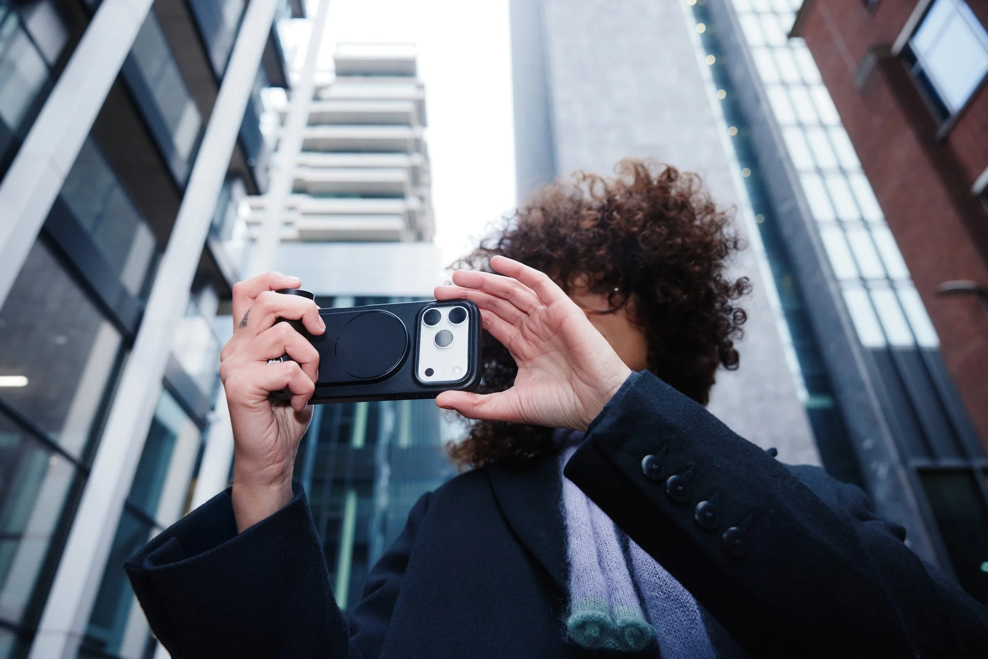 スマホにアタッチメントを付けて撮影する人物