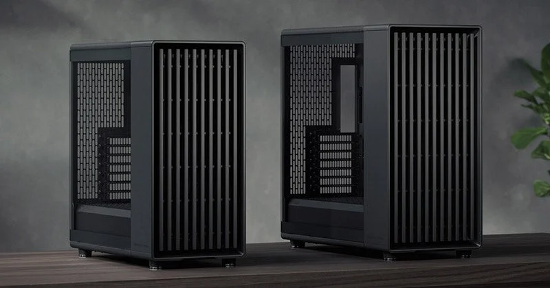 モダンでミニマルなデザインの黒いPCケースが2つ、木製の台の上に置かれている様子。側面には通気孔があり、洗練された印象を与える。